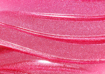 Pink shimmering lip gloss texture background. Smudged cosmetic product smear. Makup swatch product...