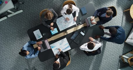 Diverse Professionals Working on Business Statistics and Marketing Plans in Corporate Office. Top Down View Of Discussion and Financial Data Analysis on Laptops and Charts. Teamwork And Innovation. - Powered by Adobe