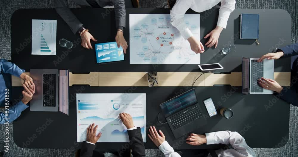 Fototapete Diverse Professionals Working on Business Statistics Reports and Digital Plans in an Office. Top Down View Of Discussion and Data Analysis on Laptops and Charts. Teamwork And Innovation Concept.