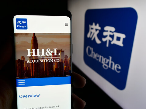Stuttgart, Germany - 06-26-2024: Person holding cellphone with webpage of investment company Chenghe Group Ltd. in front of business logo. Focus on center of phone display.