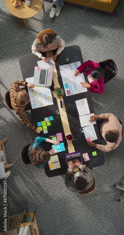 Poster vertical screen top down view: innovative teamwork at office table. diverse professionals collaborat