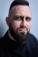 Fototapeta premium Studio portrait of young sceptical handsome man with beard.
