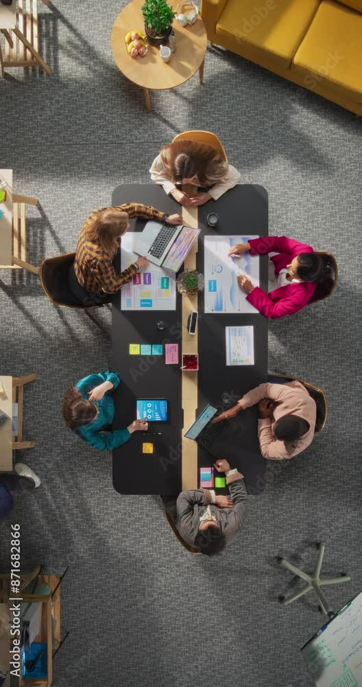 Poster vertical screen: top down view of young, diverse entrepreneurs in a colorful office, solving problem