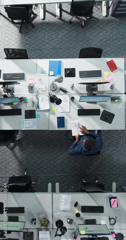 Fototapete vertical screen: top down view of male african american worker staying late at work alone in a corpo