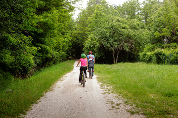 Obraz premium Young family riding bicycles in the park