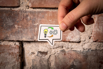IDEA and SKILL Concept.  Speech bubble in hand on red brick background