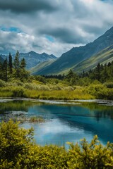 Fototapeta premium A beautiful mountain landscape with a large body of water in the foreground. The water is a deep blue color and the sky is cloudy. The scene is peaceful and serene