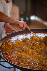 Paella Española, chef cocinando una grande y rica paella, plato típico de España.