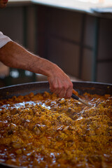 Paella Española, chef cocinando una grande y rica paella, plato típico de España.