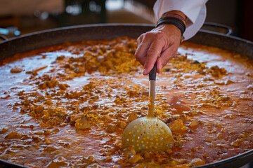 Paella Española, chef cocinando una grande y rica paella, plato típico de España.