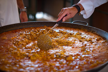 Paella Española, chef cocinando una grande y rica paella, plato típico de España.