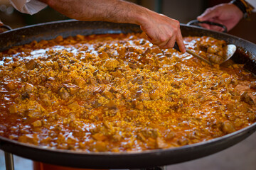 Paella Española, chef cocinando una grande y rica paella, plato típico de España.