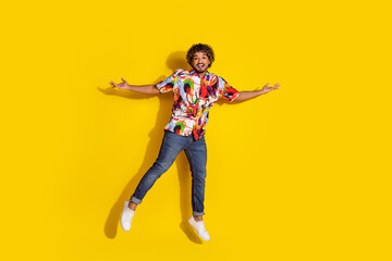 Full length photo of handsome young male jump hold empty space dressed stylish colorful garment isolated on yellow color background