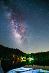 the milk way in the sky and pine forest, boats in the foreground, outdoor vacation, sequoia lake, California