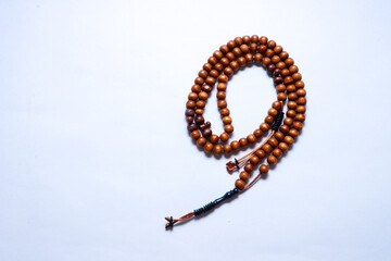 Top view of wooden simple prayer rosary isolated on white background. Copy space.

