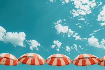 A row of red and white umbrellas are set up in the sun