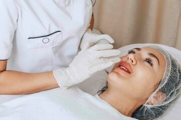 cosmetologist focuses intently while applying a treatment, professional lip care requires