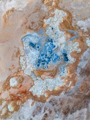 View from above, stunning aerial view of Námafjall Geothermal Area also known as Hverir with smoking fumaroles and boiling mud pots, surrounded by sulphur crystals of many different colours, Iceland.