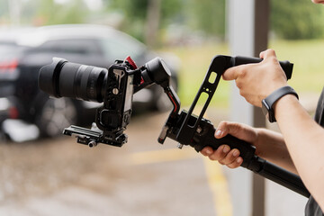 Big digital camera stabilization riga with filming professional arms close up