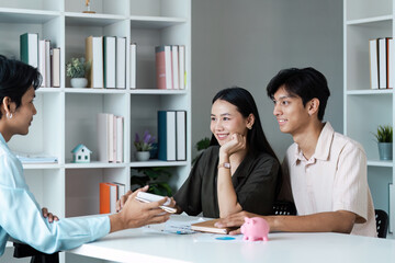 Young Couple Discussing Financial Planning with Advisor in Modern Office Setting