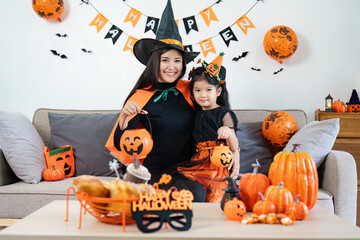 Fototapeta premium Mother and Daughter Celebrating Halloween at Home with Costumes, Pumpkins, and Festive Decorations