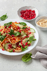 healthy halloumi cheese and couscous salad with cucumber spinach pomegranate hummus