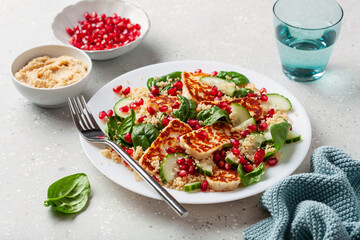 healthy halloumi cheese and couscous salad with cucumber spinach pomegranate hummus