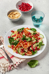 healthy halloumi cheese and couscous salad with cucumber spinach pomegranate hummus