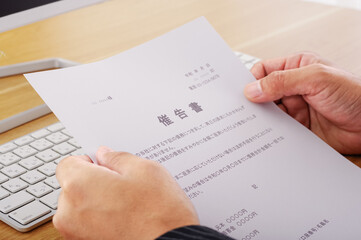 催告書を見つめる男性