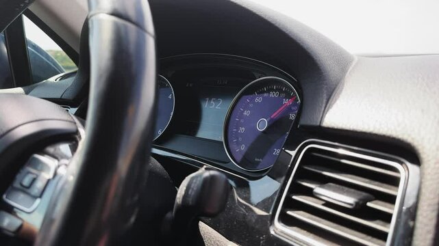 Fast speed traveling sport car dashboard with a speedometer showing a speed of 154 mph