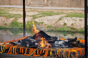 Smoldering funeral pyre for cremation ceremony at Pashupatinath Temple complex, Nepal, ancient...