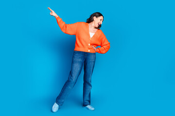 Full body photo of attractive senior woman dancing have fun dressed stylish orange clothes isolated on blue color background