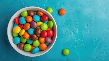 Colorful candies in bowl on colored background for birthdays and holidays Top down view with room for text