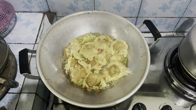 Footage of tofu fried in a skillet over medium heat