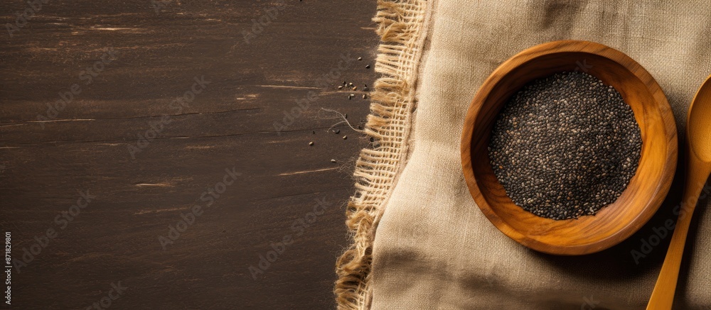 Aufkleber Flat lay featuring a wooden bowl filled with chia seeds on a textured burlap backdrop. A spoon is placed on top, emphasizing the copy space image layout.