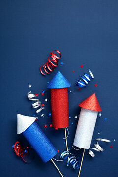 Firework rockets on dark blue background with party streamers and confetti. US Independence Day 4h of July concert.