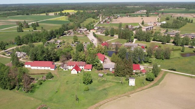 Aerial view of the small town of Malien, located in a green park. The parish is surrounded by well-maintained paths, trees and open grass. Residential buildings and parking