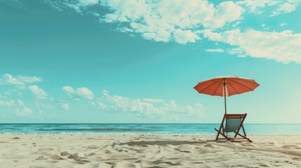 An empty lounge chair under an umbrella on the beach, space for text in the sand and sky.