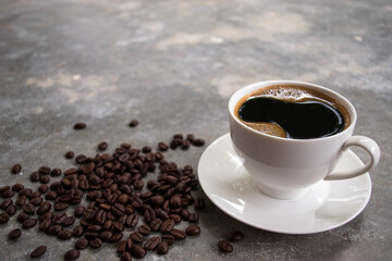 Side view black coffee in a white glass placed on an old cement table with coffee beans.