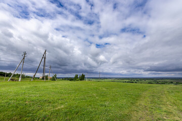 A field of grass with a few birds flying in the sky