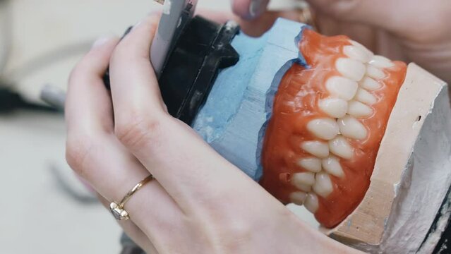 Dental Technician Carefully Adjusting a Prosthesis in a Lab Setting
