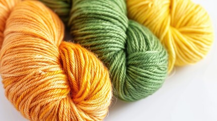 Yarn skeins in yellow orange green hues on white backdrop