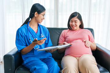 Asian female doctor and nurse perform an ultrasound on a pregnant woman, using a stethoscope and medical equipment, ensuring her health and preparing for a successful birth.