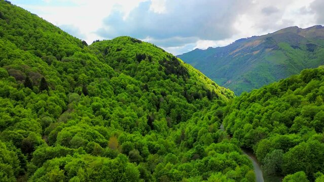 Aerial view of the Alpine mountain peaks on the border of Italy and Switzerland. The drone flies between green slopes and dramatic clouds. Trekking and tourism in the mountains. Green Paneth. Oxygen. 