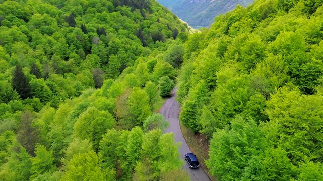 Aerial view of the Alpine mountain peaks on the border of Italy and Switzerland. The drone flies between green slopes and dramatic clouds. Trekking and tourism in the mountains. Green Paneth. Oxygen. 