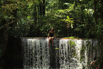 mulher em cachoeira cercada de floresta em Rio Preto da Eva, Amazonas 
