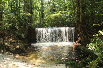mulher em cachoeira cercada de floresta em Rio Preto da Eva, Amazonas 