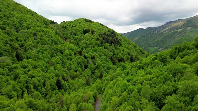 Aerial view of the Alpine mountain peaks on the border of Italy and Switzerland. The drone flies between green slopes and dramatic clouds. Trekking and tourism in the mountains. Green Paneth. Oxygen. 