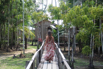 mulher caminhando em palafitas em hotel de selva, no Amazonas 