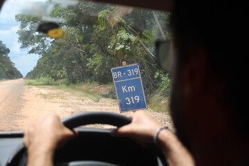 carro comum na BR-319, no Amazonas, em período de seca, quando há muita poeira no trecho sem...